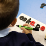 Child using the monster phonics magnetic letters in a classroom