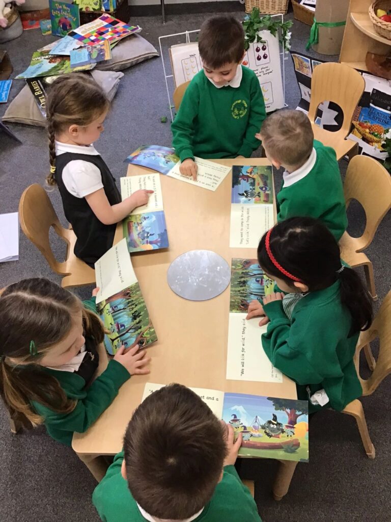 Children reading monster phonics books in a group