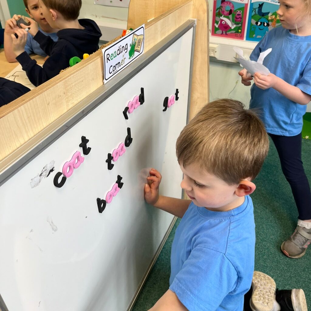 Children using the monster phonics magnetic letters in a classroom at school